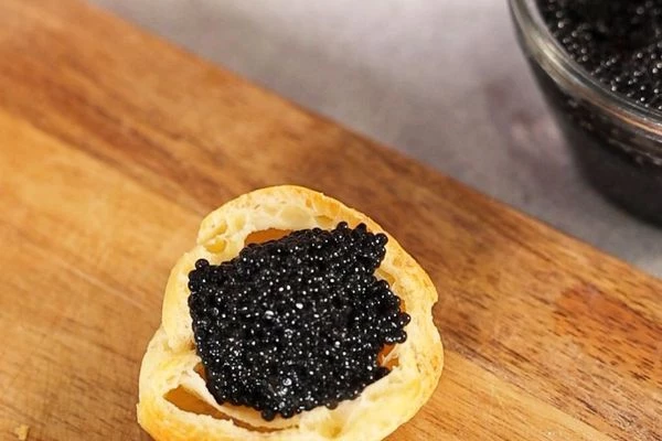 В оставшиеся профитроли выложить черную икру щуки.

