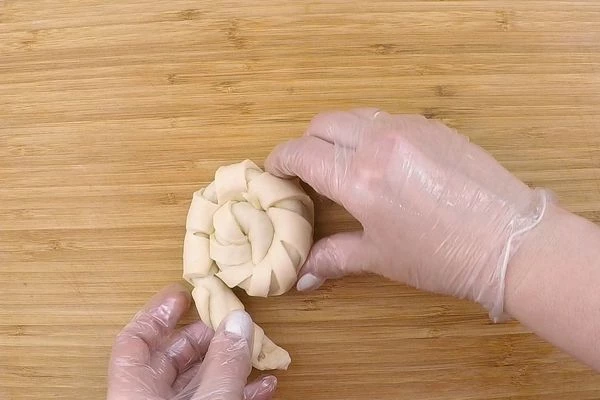 Скатать в тонкий рулет, а затем завернуть рулет в виде «улитки». Можно шар не делить пополам, а сделать большую булочку).