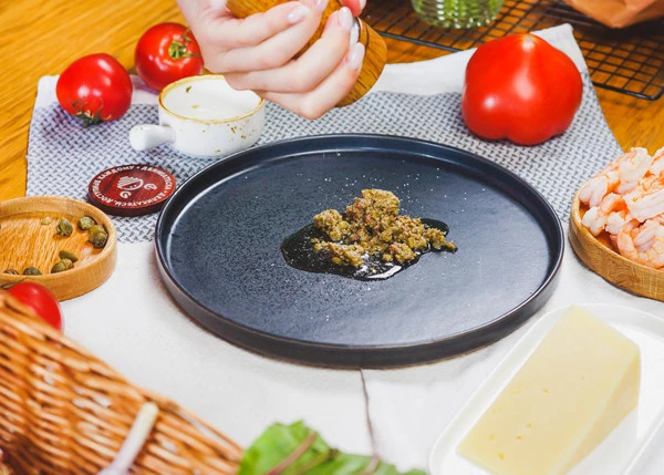  На тарелку для подачи выложить анчоусы с каперсами, добавить масло, тертый пармезан, посолить, перемешать ложкой.