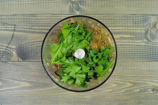 Чеснок и острый перец пробить в блендере, добавить приправу, по желанию можно добавить веточки кинзы.