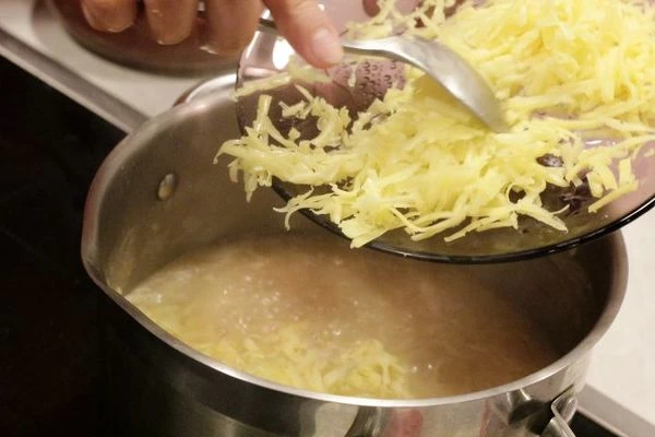Половину натертого сыра добавить в кастрюлю, хорошо перемешать и снять с огня. Разлить по горшочкам.