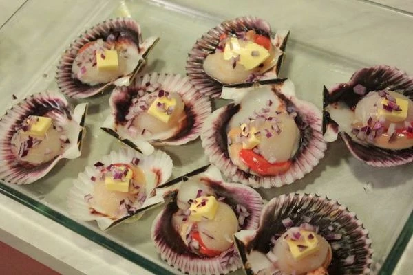 Не снимая с раковины, выложить в форму для запекания. В каждую раковину положить по небольшому кубику сливочного масла и мелко нарезанный красный лук.