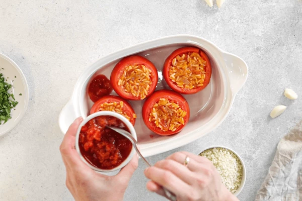 Нафаршировать томаты, посыпать сверху сухарями и нарезанной петрушкой. Между томатами распределить оставшиеся томаты в собственном соку.