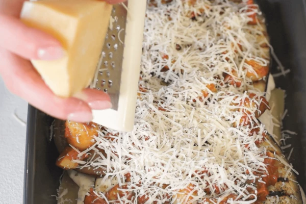 По всей поверхности распределить натертый пармезан.
