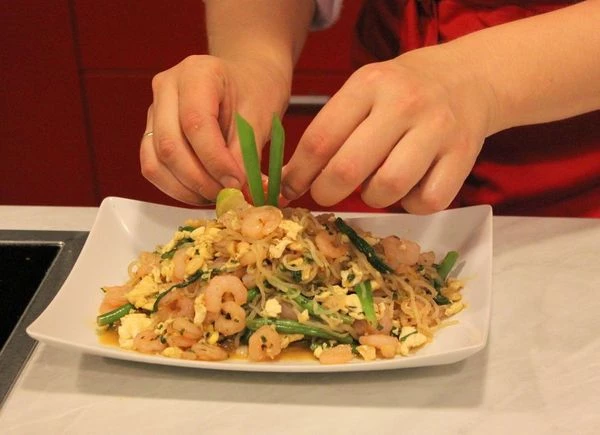 Выложите на тарелку, украсьте зеленым луком и долькой лайма.