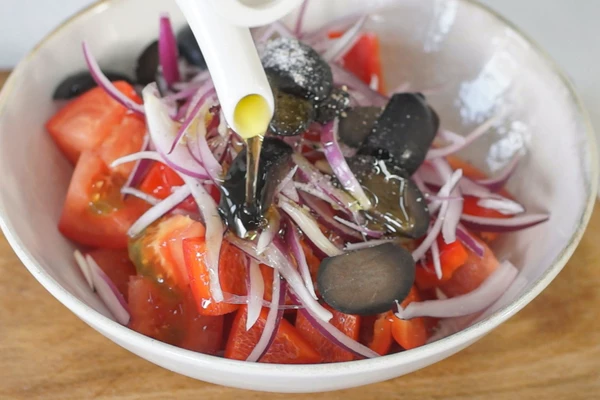 Маслины нарезать.
Перец, томаты, маслины и лук смешать, заправить оливковым маслом, посолить и поперчить.

