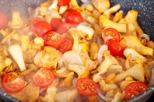  Теперь на хорошо разогретую сковороду наливаем еще немного оливкового масла, обжариваем лук до золотистого цвета, добавляем грибы, жарим еще 3-4 минуты. Затем солим, перчим, добавляем половинки помидоров и петрушку. 