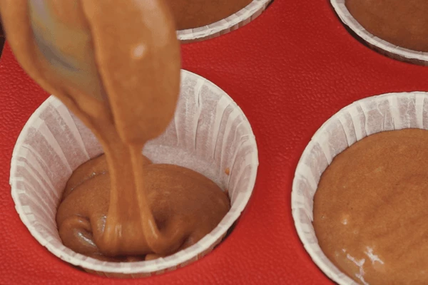 Готовое тесто разлить по бумажным формочкам, заполняя на 1/3 часть. Не стоит больше наливать теста, так как при выпечке бисквит дает хороший подъем