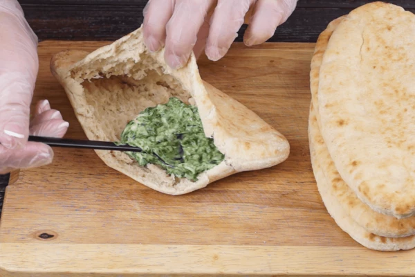 Готовую питу разрезать с боку, чтобы получился "кармашик", выложить внутрь начинку.