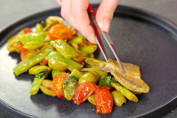 На тарелку для подачи выложить гарнир. Рядом выложить обжаренную барабульку. Оформить листочками базилика.
