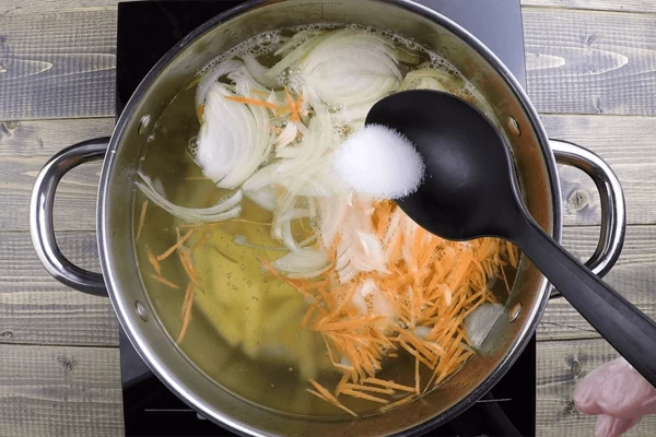 Варить до полу готовности, затем добавить лук и морковь, фрикадельки. Посолить, поперчить по вкусу. 