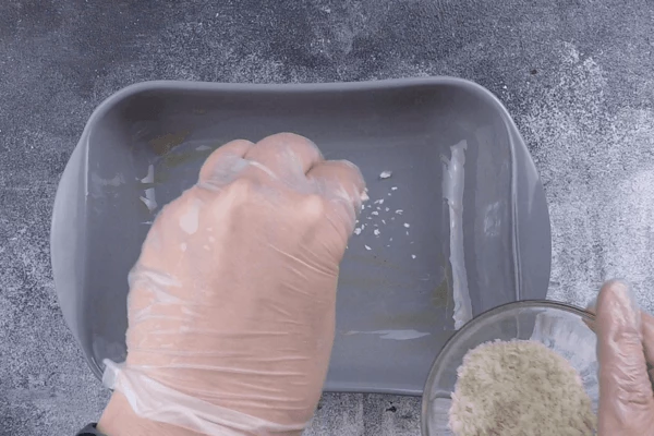  Форму для запекания смазать оливковым маслом и посыпать оставшимися сухарями. 