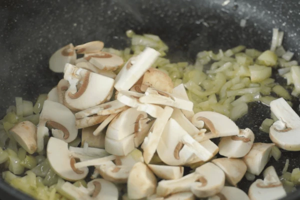 Лук обжарить на масле, ввести грибы, соль, перец, перемешать, обжаривать пару минут.