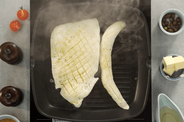 На сковороду гриль налить оливковое масло и обжарить каракатицу. 