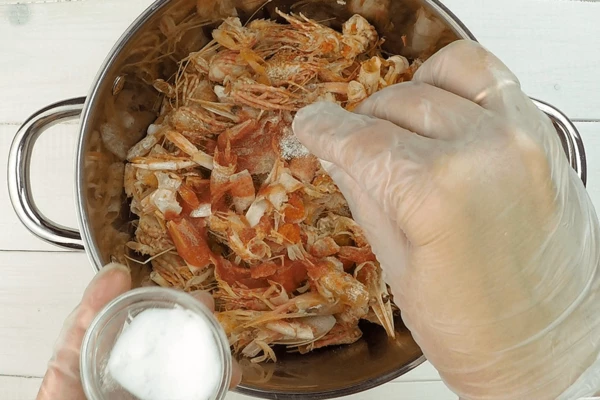 Обжаренные панцири креветок выложить в глубокую кастрюлю, влить томаты, белое вино, немного подсолить.