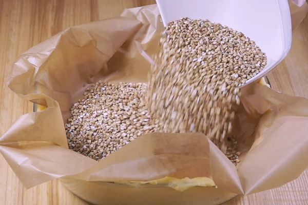 Чтобы тесто пропеклось и не раздулось в пузырь, можно сверху выложить лист пергамента и засыпать гречкой или фасолью. Поставить в разогретую до 180-200С духовку, 5-7 минут выпекать с пергаментом, затем убрать пергамент и поставить еще на минут 5-7 (в зависимости от мощности Вашей духовки).