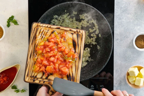 Добавить нарезанную томатную мякоть и сок от томатов, жарить пару минут.