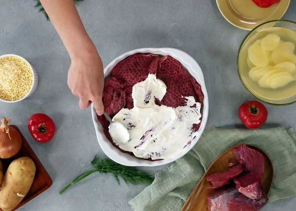 Смешать сметану с майонезом, смазать мясо.