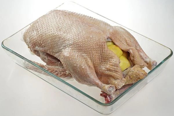 Подготовленную тушку муларда переложить в лоток для запекания, нафаршировать яблоками и чесноком. Можно добавить пару стручков перца чили.