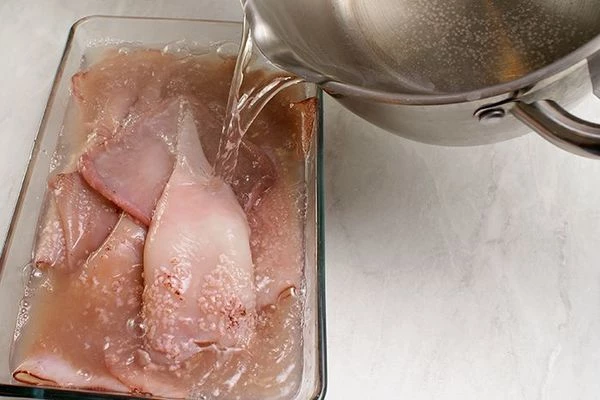 Кальмар разморозить естественным способом на нижней полке холодильника. Залить кипятком на 1-2 минуты, чтобы сошла шкурка.