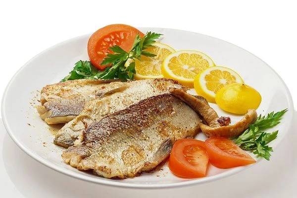 Подавать с свежими овощами, дольками ароматного лимона и зеленью.