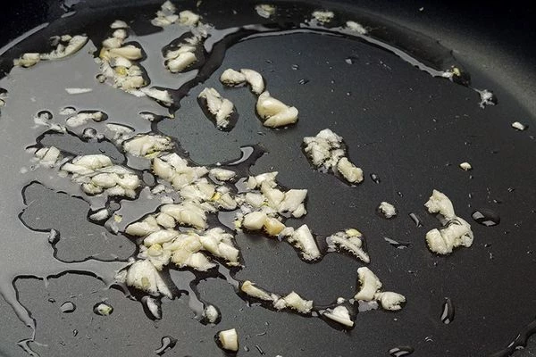 На разогретой с растительным маслом сковороде слегка обжарить мелко нарезанный чеснок.