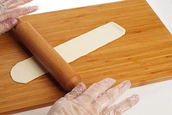 Раскатайте тесто в длинную полоску, толщиной примерно 3-4мм.