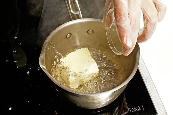 В кастрюле довести до кипения воду и маргарин.