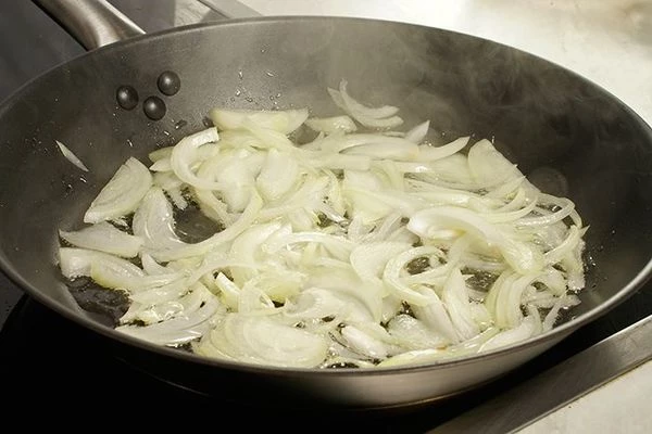 На разогретой с оливковым маслом сковороде обжарить лук до мягкости.