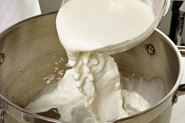 В глубокую миску налить теплое молоко.