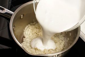 Рис промойте несколько раз, замочите на 10 минут в теплой воде. Затем слейте воду, переложите в кастрюльку и залейте кокосовым молоком