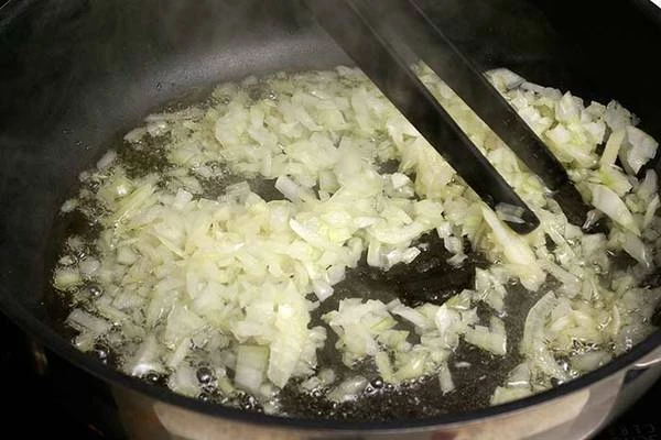 Лук нарезать мелким кубиком. Обжарить на разогретой с оливковым маслом сковороде до прозрачности.