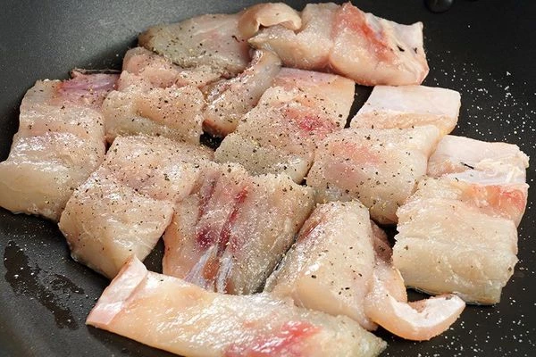 Филе кефали с кожей выложить на смазанную растительным маслом сковороду, посолить, поперчить.