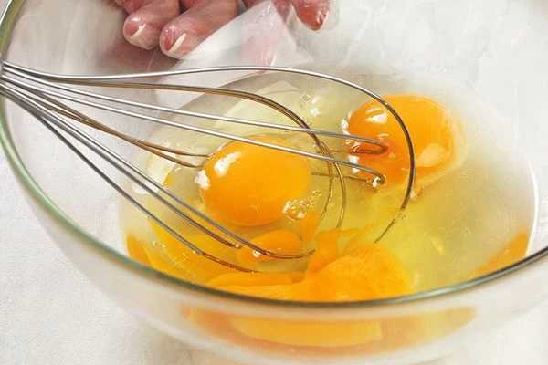 Яйца перелить в глубокую миску, взбить венчиком.