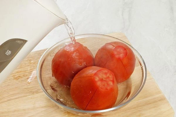 На помидорах сделать с 4 сторон надрезы, затем ошпарить кипятком.