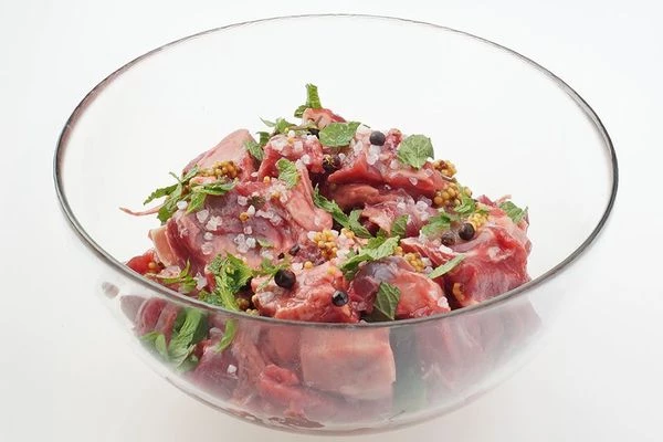Замариновать мясо в смеси растительного масла, специй, горчицы и свежей мяты. Посолить, поперчить по вкусу. Оставить на 30-40 минут.