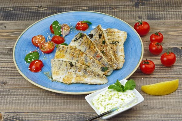 Украсить готовое филе дольками лимона и помидорами.
