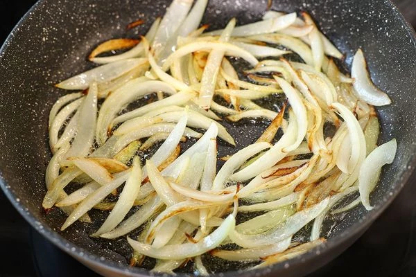 Лук очистить, нарезать дольками и обжарить на подсолнечном масле. 