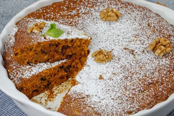 Готовый кекс посыпать сахарной пудрой и украсить орехами.