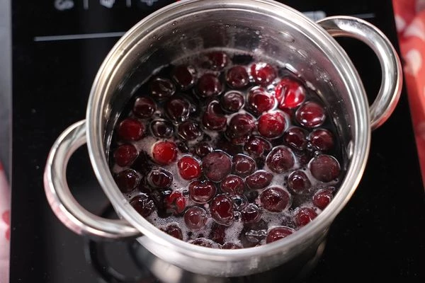 В сироп засыпать вишню, перемешать. Оставить на два часа при комнатной температуре. 