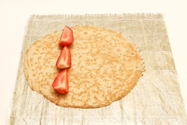 Клубнику нарезать  брусочками и выложить на блин