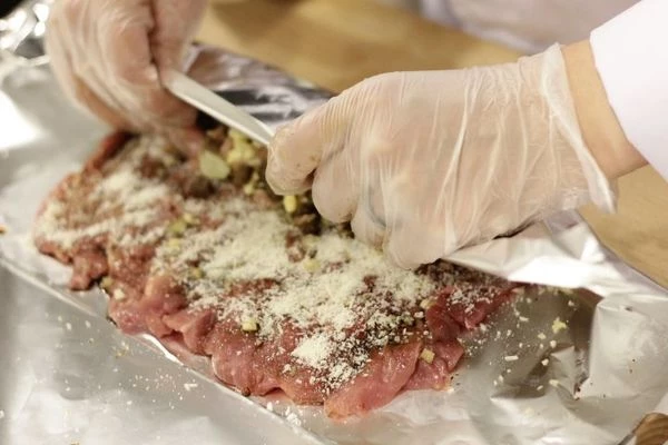 Ближе к краю выложить начинку, плотно завернуть, с помощью фольги, в рулет.