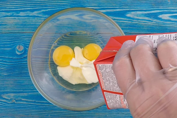  Приготовить заливку: в глубокой чашке взбить венчиком яйца со сливками.