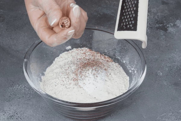 Отдельно в чашке смешать муку, разрыхлитель, соль и натертый мускатный орех. 