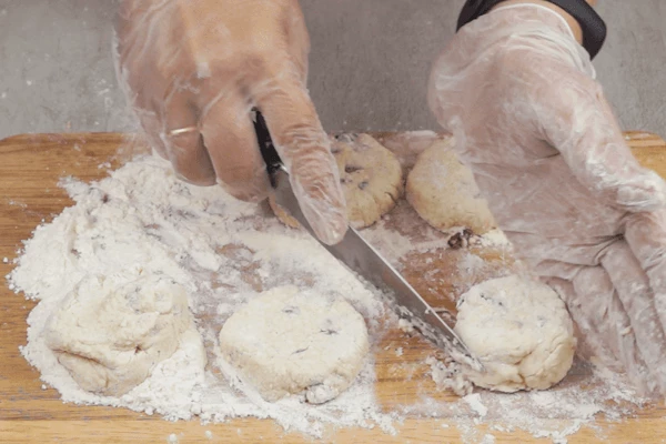 Сформовать в виде толстой колбаски. Ножом разрезать на порции, обвалять в муке и сформовать круглые сырники, слегка выравнивая ножом.
