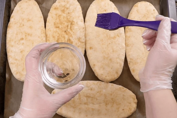 Питу разморозить естественным способом в холодильнике. Затем смазать водой и поставить в разогретую до 180С духовку на 2-3 минуты, чтобы она прогрелась.