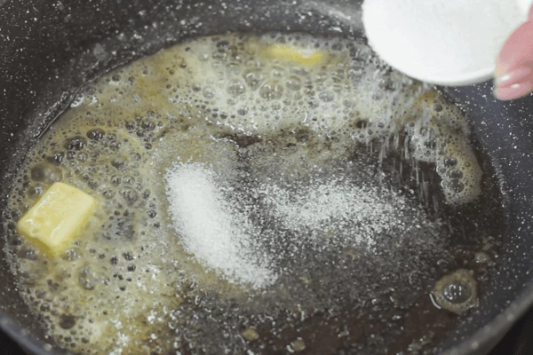 В сковороду добавить нарезанное кубиками сливочное масло, сахар и выдавить сок лайма, слегка уварить, интенсивно помешивая. 