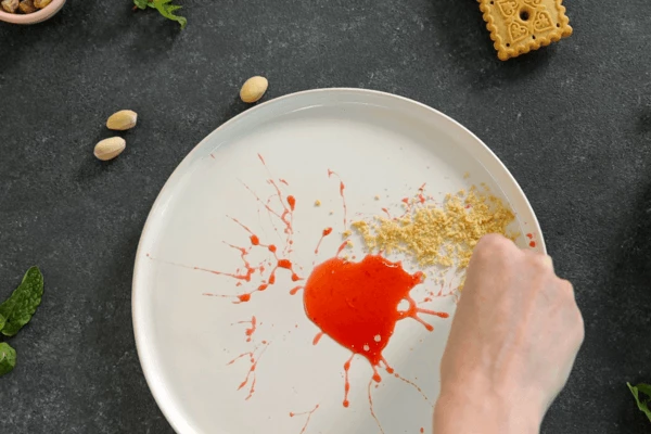 Печенье измельчить в крошку. Рядом с соусом насыпать крошку из печенья. 