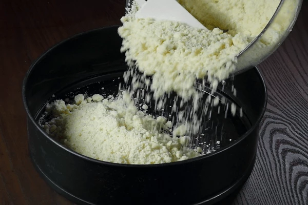  В форму для выпечки выложить 2/3 части теста-крошки в один слой.