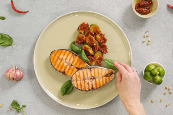 На тарелку для подачи выложить капусту и стейки. Оформить листиками базилика. Подавать с соусом песто.

